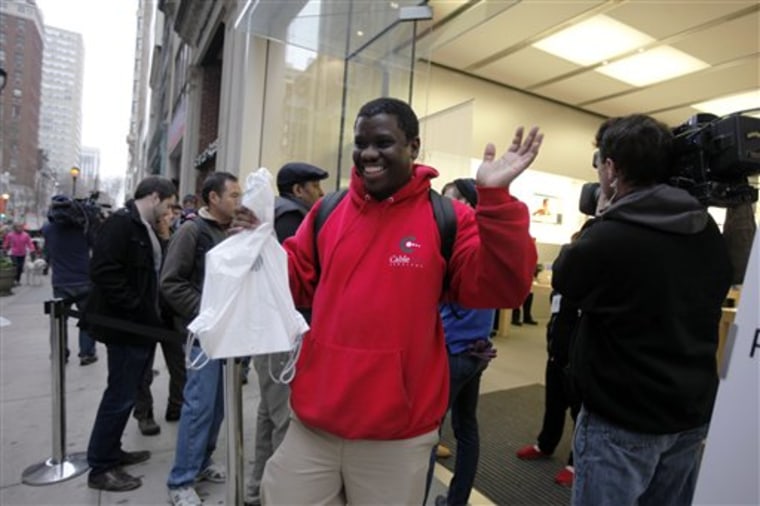 Robert Smith exits an Apple retail store with a new iPad tablet, Friday, March 16, 2012, in Philadelphia. Stores along the East Coast have begun selling Apple's latest tablet computer. It's going on sale at 8 a.m. local time Friday in the U.S. and nine other countries. (AP Photo/Matt Rourke)